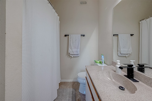 bathroom featuring tile patterned flooring, vanity, and toilet