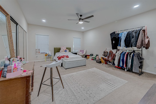 bedroom with ceiling fan, light colored carpet, and a closet