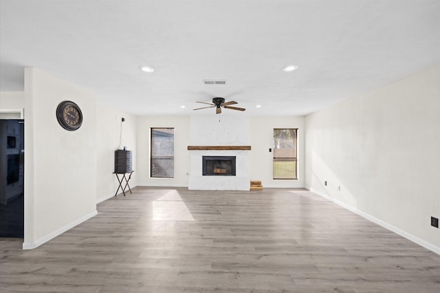 unfurnished living room with a fireplace, light hardwood / wood-style flooring, and ceiling fan