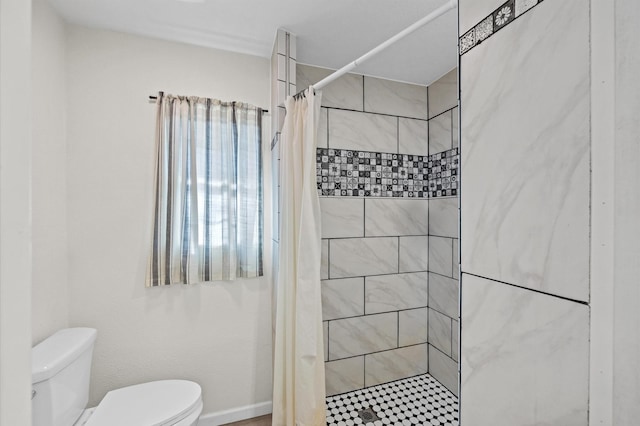 bathroom with a shower with shower curtain and toilet