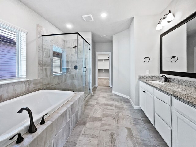 bathroom featuring vanity and independent shower and bath