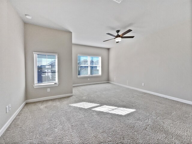 carpeted spare room with ceiling fan