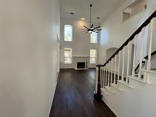 foyer entrance featuring ceiling fan, dark hardwood / wood-style flooring, and a high ceiling