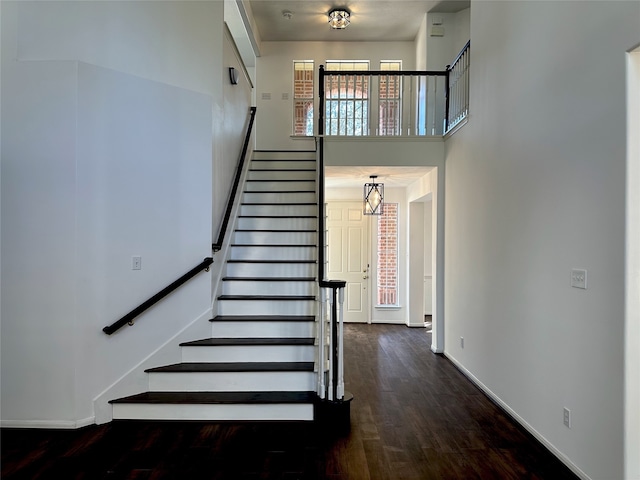 stairs featuring hardwood / wood-style flooring and a chandelier