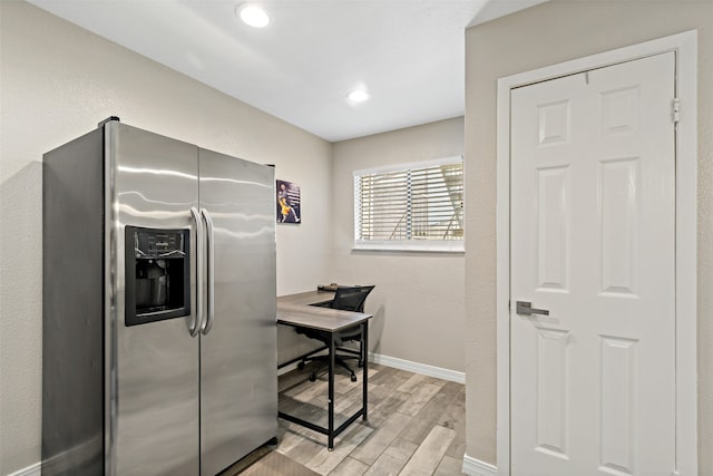 kitchen featuring stainless steel fridge and light hardwood / wood-style floors