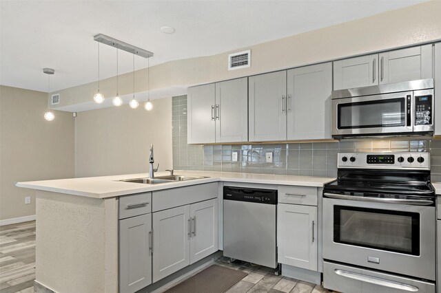 9000 Bissonnet St Unit 501, Houston, TX 77074 - kitchen with appliances with stainless steel finishes, a sink, light wood-style flooring, a peninsula, and tasteful backsplash