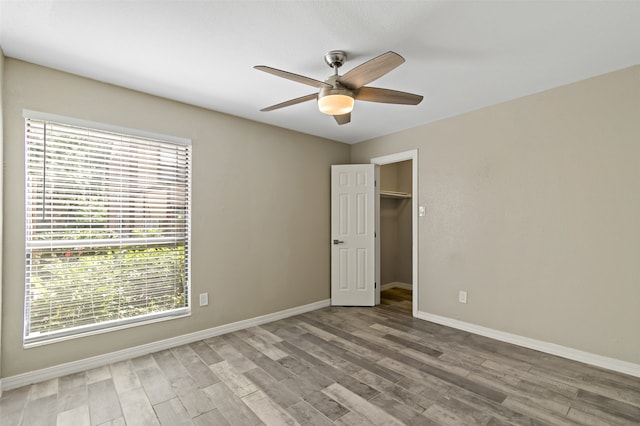 spare room with ceiling fan, wood-type flooring, and a wealth of natural light