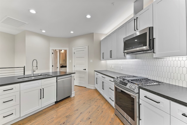 kitchen with white cabinets, light hardwood / wood-style flooring, sink, and stainless steel appliances