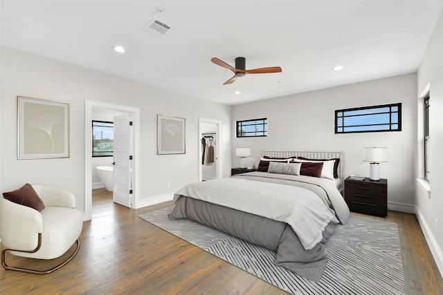 bedroom with ceiling fan, a spacious closet, connected bathroom, dark hardwood / wood-style flooring, and a closet