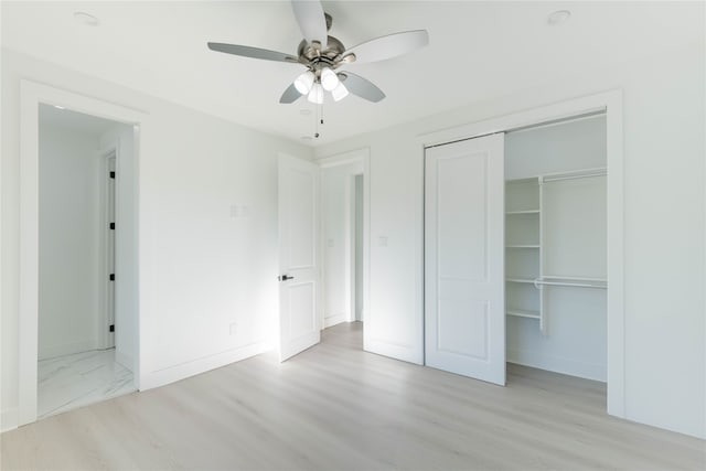 unfurnished bedroom featuring ceiling fan, light hardwood / wood-style floors, and a closet