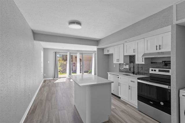 12900 Walden Rd Unit 419D, Montgomery, TX 77356 - kitchen with stainless steel range with electric stovetop, dishwasher, a sink, under cabinet range hood, and decorative backsplash