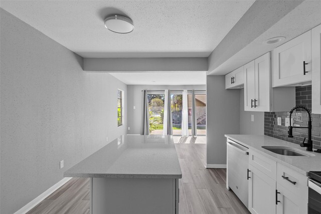 12900 Walden Rd Unit 419D, Montgomery, TX 77356 - kitchen with dishwasher, a sink, decorative backsplash, baseboards, and a textured ceiling