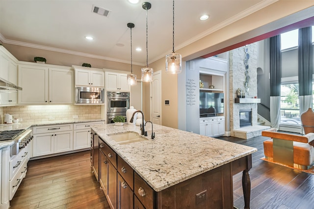 kitchen featuring a kitchen island with sink, white cabinets, dark hardwood / wood-style floors, and appliances with stainless steel finishes