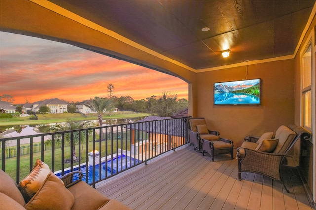 deck at dusk featuring a water view and a pool