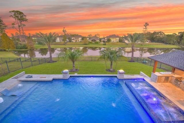 pool at dusk with a water view and a lawn