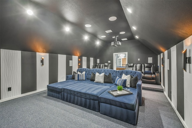 carpeted home theater room featuring a textured ceiling and vaulted ceiling