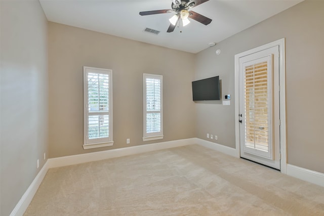 carpeted spare room featuring ceiling fan