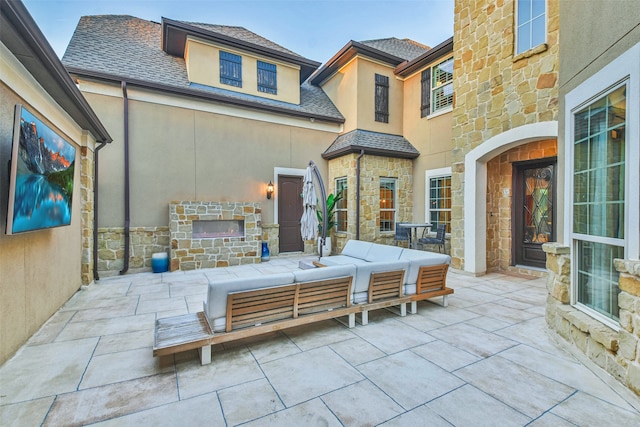 view of patio with an outdoor living space with a fireplace