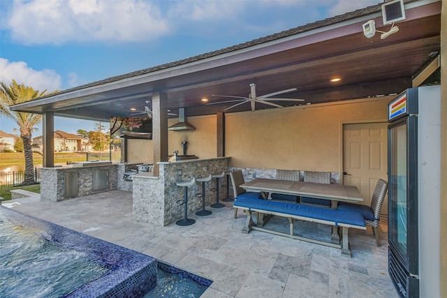 view of patio / terrace featuring an outdoor bar, ceiling fan, and exterior kitchen