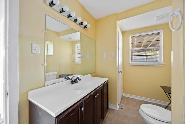 bathroom with toilet, vanity, tile patterned floors, and a healthy amount of sunlight