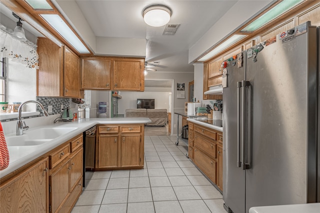 kitchen with stainless steel refrigerator, ceiling fan, sink, kitchen peninsula, and light tile patterned floors