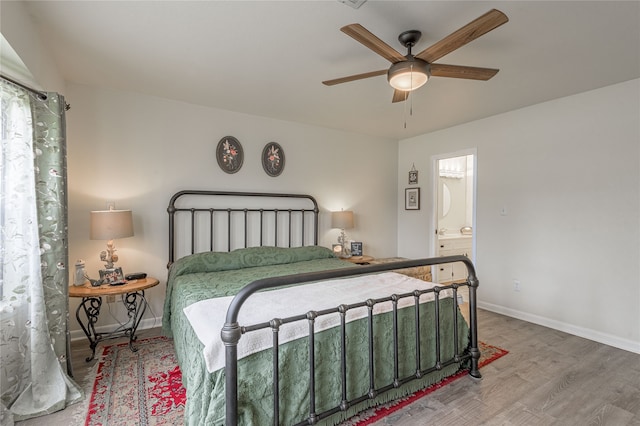 bedroom featuring hardwood / wood-style floors, ceiling fan, and ensuite bath