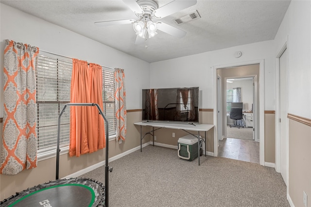 office space with a textured ceiling, carpet floors, and ceiling fan