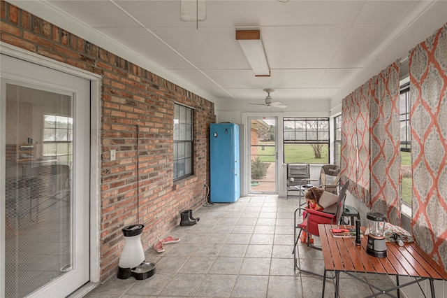 unfurnished sunroom with ceiling fan