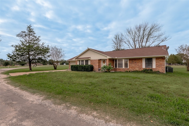 ranch-style house featuring central AC unit and a front lawn