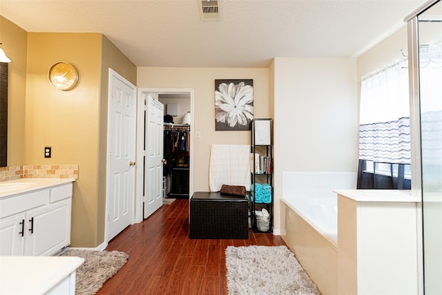 bathroom with a bathtub, vanity, and hardwood / wood-style flooring