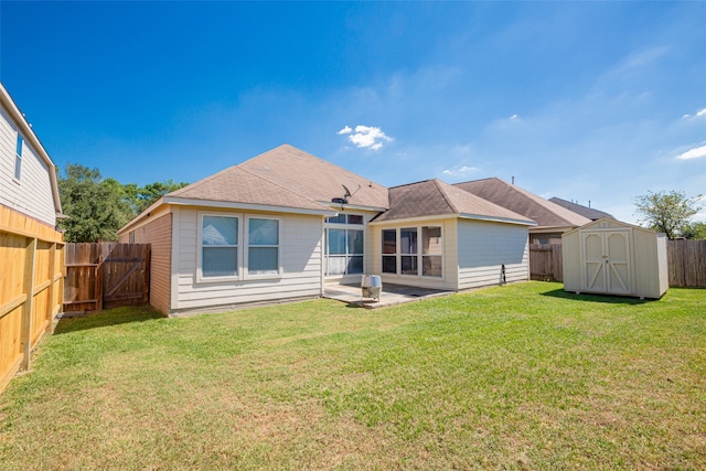 back of house with a storage shed, a patio area, and a lawn