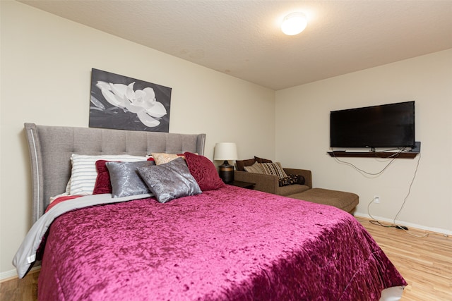 bedroom with a textured ceiling and hardwood / wood-style flooring