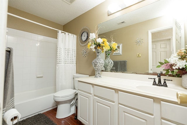 full bathroom with wood-type flooring, a textured ceiling, toilet, vanity, and shower / tub combo