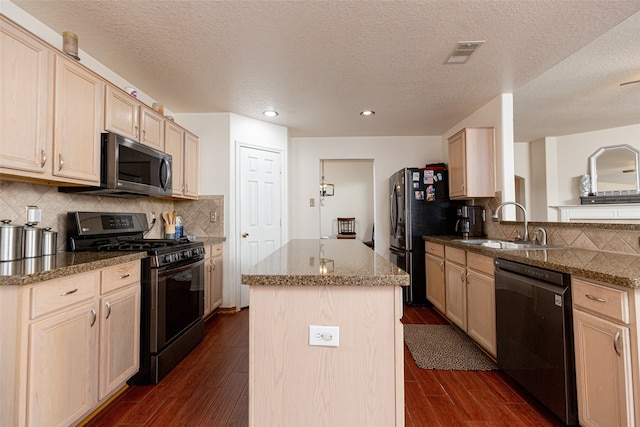 kitchen with light brown cabinetry, a kitchen island, dark wood-type flooring, and black appliances