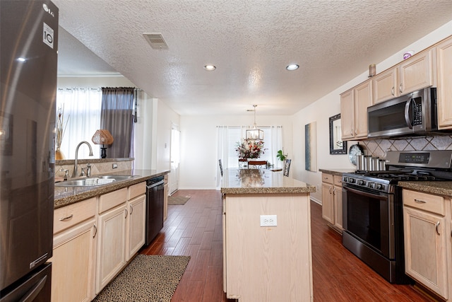 kitchen featuring a center island, a healthy amount of sunlight, dark wood-type flooring, and appliances with stainless steel finishes