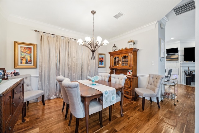 dining room featuring crown molding, wood-type flooring, and a notable chandelier