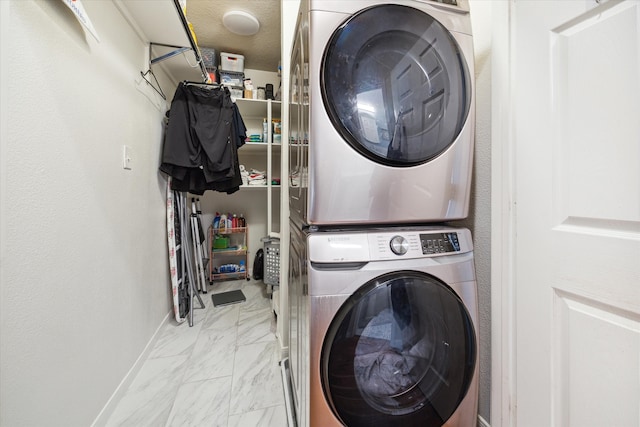 laundry area featuring a textured ceiling and stacked washer / drying machine