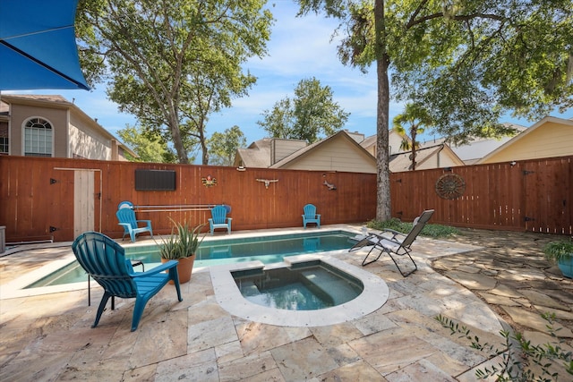 view of pool with a patio area and an in ground hot tub