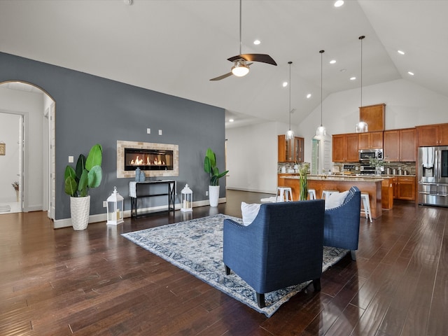 living room featuring dark hardwood / wood-style floors, ceiling fan, and high vaulted ceiling