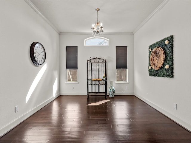 entrance foyer with dark hardwood / wood-style flooring, an inviting chandelier, and ornamental molding