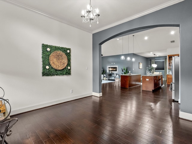 living room featuring crown molding, dark wood-type flooring, and an inviting chandelier