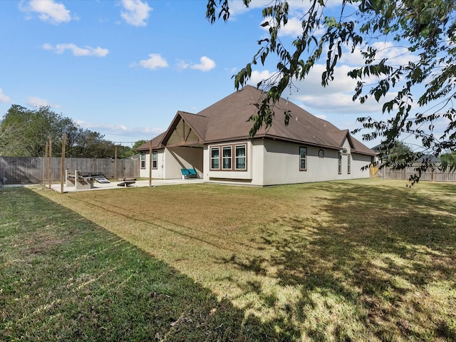 back of property featuring a lawn and a patio