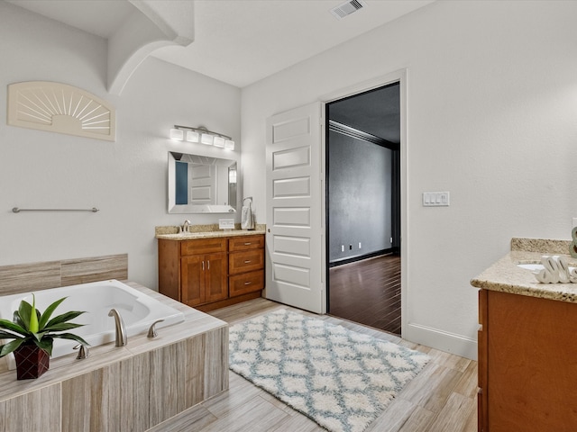 bathroom featuring a bathing tub, vanity, and hardwood / wood-style flooring