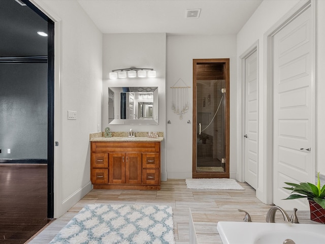 bathroom featuring hardwood / wood-style floors, vanity, and separate shower and tub