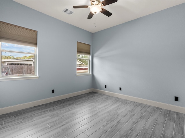 unfurnished room with light hardwood / wood-style flooring, ceiling fan, and a healthy amount of sunlight