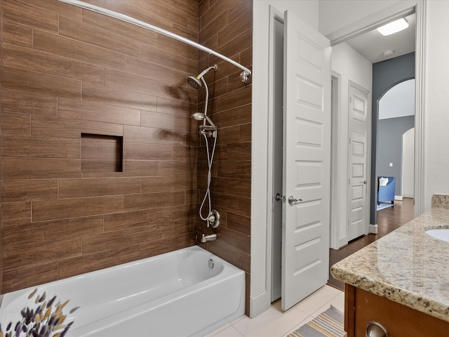 bathroom with tile patterned floors, vanity, and tiled shower / bath