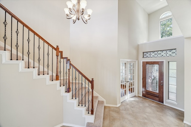 entrance foyer with french doors, a high ceiling, and a chandelier