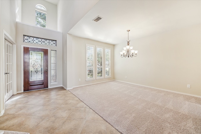 entryway with light carpet and a notable chandelier