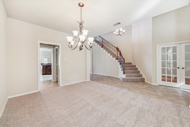 empty room featuring french doors, light colored carpet, and an inviting chandelier