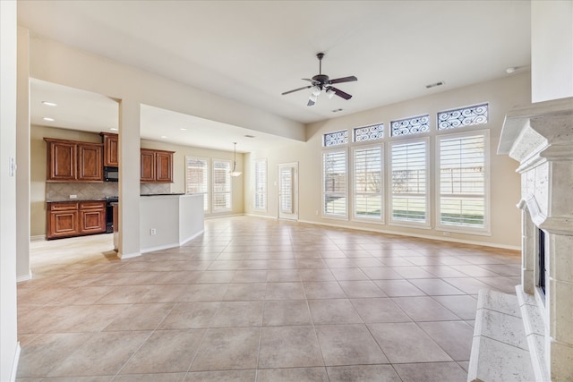 unfurnished living room featuring light tile patterned floors and ceiling fan